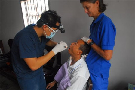 Dentist and assistant treating patient