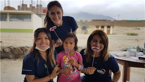 Patient and nurses holding up paper smiles