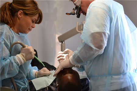 Dentist and assistant treating patient