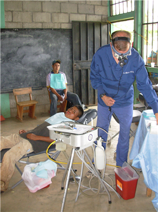 Boy in chair with dentist standing by his side