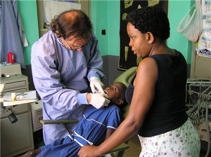 Dentist examining child with mother looking on