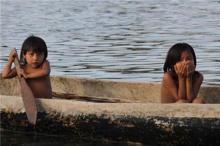 Two small children in a dug-out canoe