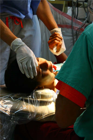 Photo of patient receiving care while holding the hand of a caregiver