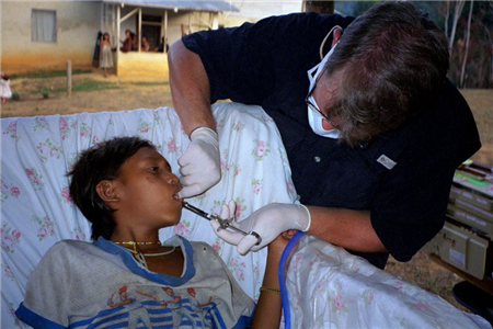 Photo of dental volunteer providing care to a young person